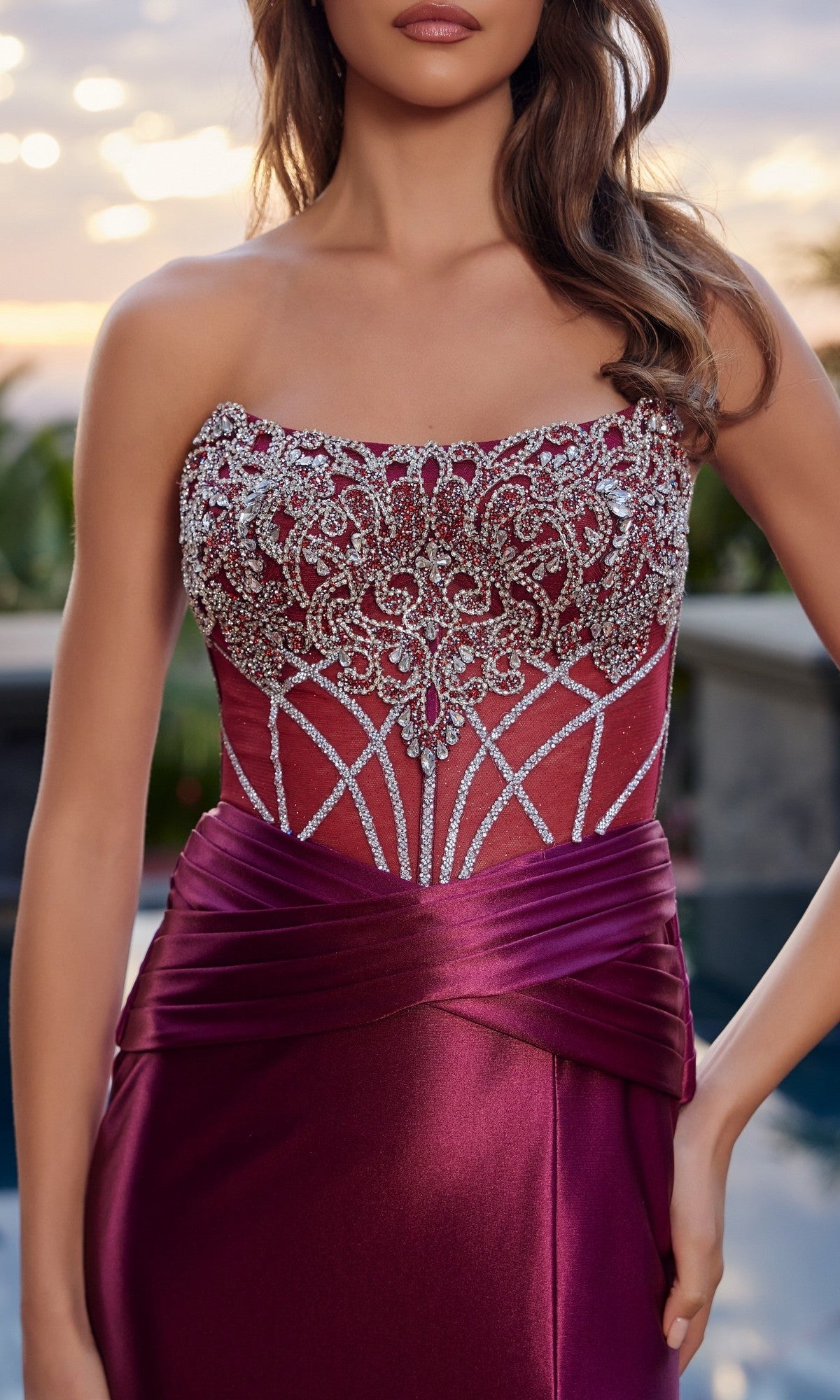 A woman wearing the Nox Anabel L1771 long prom dress—strapless with a satin finish, beaded bodice, and silver detailing—photographed outdoors.